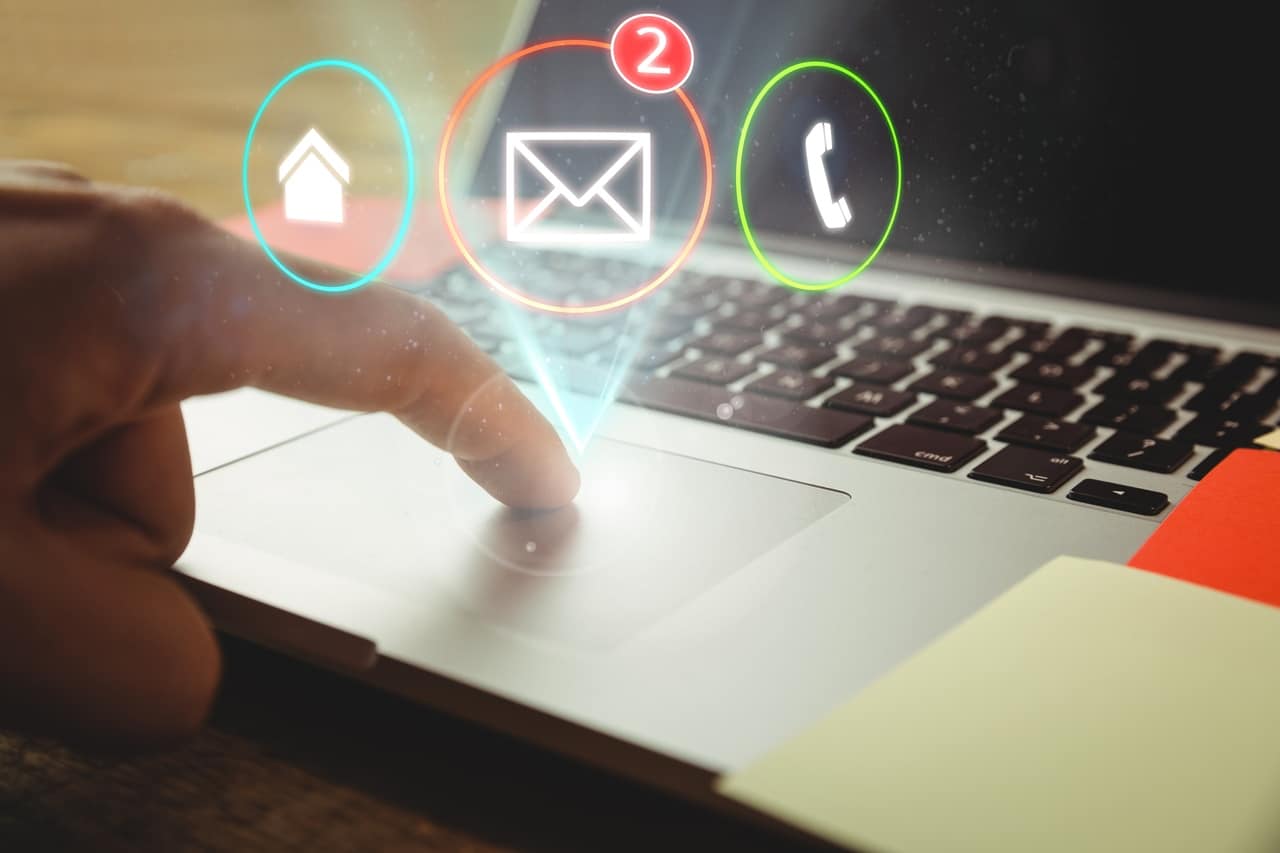 Imagem de um dedo apertando no mouse de um computador com algumas imagens ilustrativas como telefone, e-mail, para simbolizar o bloqueador de spam