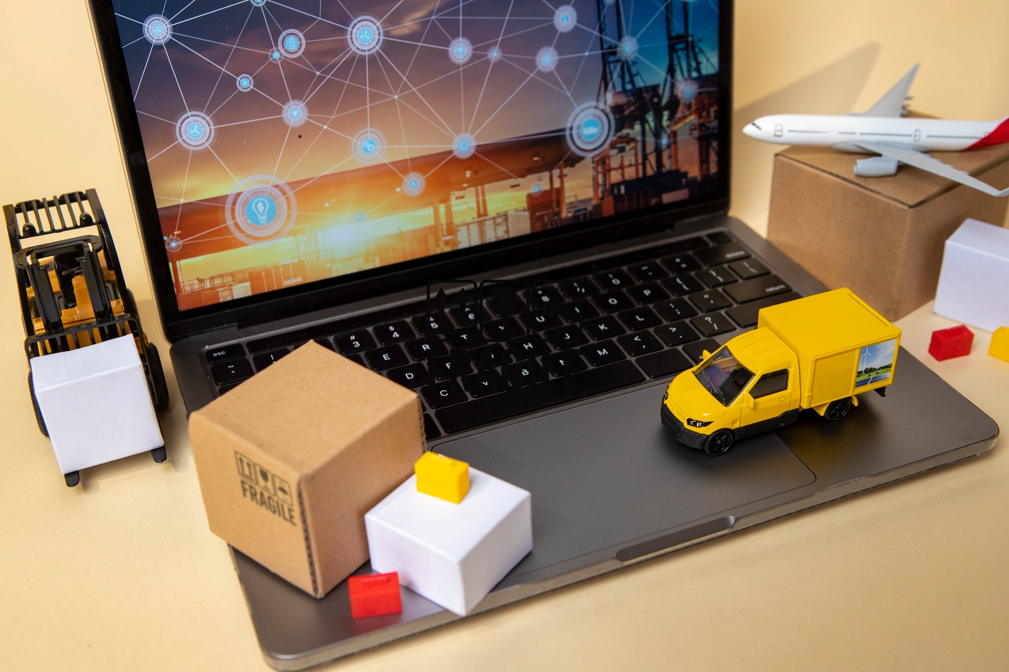Imagem de um notebook com minis caixas e caminhões para simbolizar o PABX para transportadoras